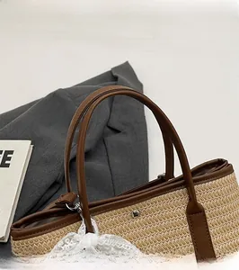 Détail du sac seau en paille tressée avec poignée ronde en cuir et dentelle blanche