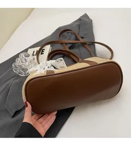 Détail du tissage de paille de qualité et du fond en cuir marron du sac fourre-tout