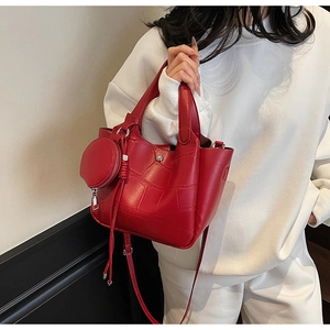 Détail du sac à main rouge texture crocodile avec un petit porte-monnaie rond assorti