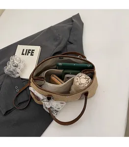 Détail de l'intérieur du sac seau en paille montrant une grande capacité et une poche zippée