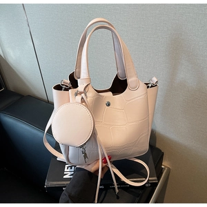 Détail du sac seau rose clair à motif crocodile avec son petit porte-monnaie assorti