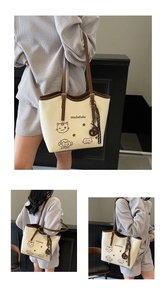 Detail of beige tote bag featuring cute cat illustrations and star patterns with brown trim