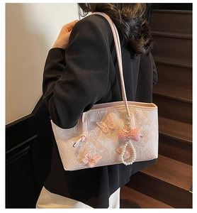 Close-up of pink lace shoulder bag with 3D butterfly embroidery and pearl charm