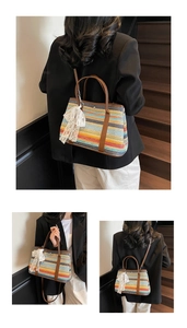 Détail du sac seau tissé coloré avec poignées en cuir et breloque en dentelle