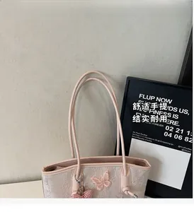 Close-up of pink tote bag with 3D butterfly embroidery and floral patterns