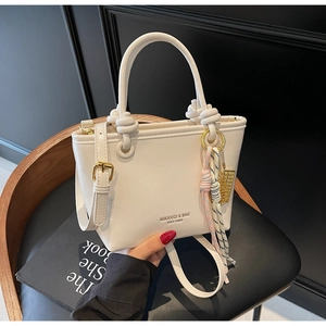 Detail of cream white PU leather bucket bag with knotted handle and MIKAXIQI logo print