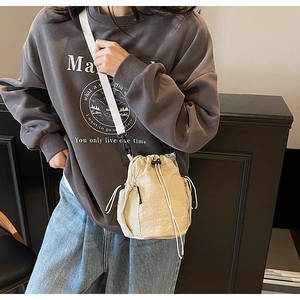 Detailansicht einer beigen Tunnelzug-Beuteltasche mit seitlicher Netztasche und breitem Gurt
