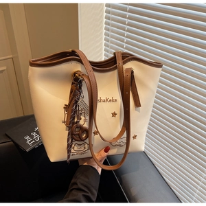 Detailed close-up of cat embroidery and premium leather straps on cream tote bag