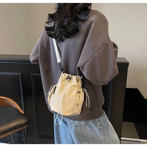 Detailansicht beige Nylon-Beuteltasche mit Netz-Seitentasche und breitem Schultergurt