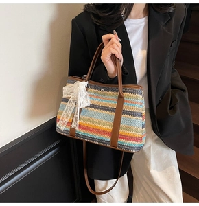 Détail du sac seau en paille arc-en-ciel avec nœud en dentelle et bandoulière en cuir