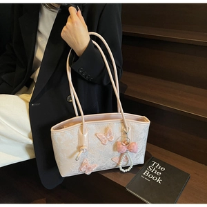 Pink lace shoulder bag with 3D butterfly embroidery and pearl charm on a model
