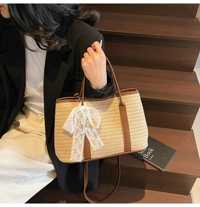 Détail d'un sac seau en paille tissé main avec bordure en cuir marron et nœud en dentelle