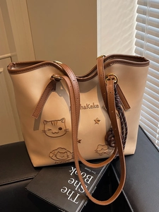 Minimalist beige tote bag with cute cat embroidery and brown straps for daily commute