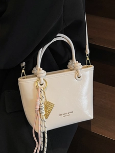Classic cream white bucket bag with knotted handles and woven charm detail