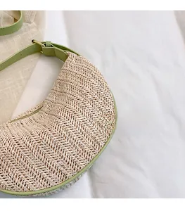 Detailed close-up of woven texture and green PU leather strap on straw crossbody bag