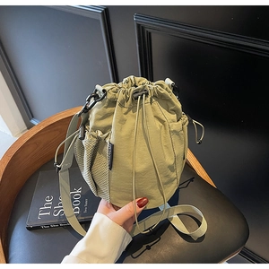 Detailansicht der olivgrünen Nylon-Beuteltasche mit seitlicher Netztasche und Gurt