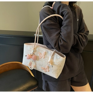 Detail of white lace tote bag with pink butterfly 3D appliques and pearl bow charm