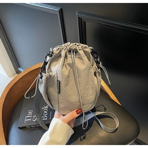Detail der hellgrauen Nylon-Beuteltasche mit Kordelzug, Netztasche und Markenetikett