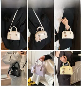 Fashionable patent leather Boston bags in various colors with cute doll pendants