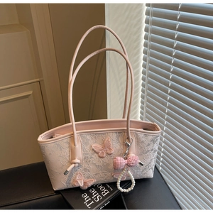 Detail view of pink lace shoulder bag with 3D butterflies and pearl bow charm