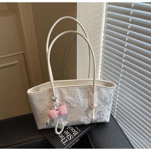 Detailed close-up of white lace shoulder bag with 3D butterfly floral applique and pearl charm