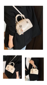 Creamy patent leather square handbag shown styled with a black blazer on a model
