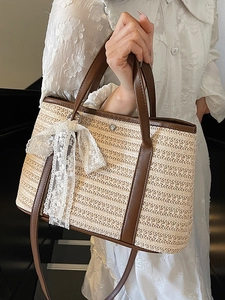 Sac seau en paille tressée avec poignées en cuir marron et nœud en dentelle blanche