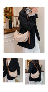 Detail view of woven half-moon bag with caramel leather trim and adjustable shoulder strap
