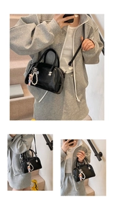 Detail of glossy black patent leather square handbag with pearl and cartoon charm