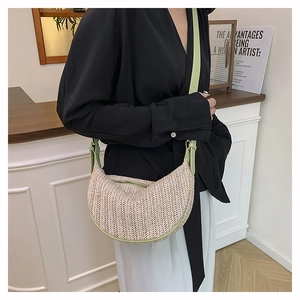 Detail of hand-woven straw crossbody bag with light green leather trim and zip closure