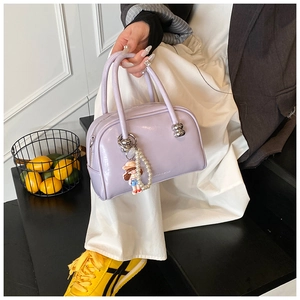 Detail of lavender Boston bag featuring glossy finish and a cute pearl charm