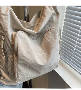 Macro shot of beige nylon material texture and slogan print on a casual shoulder bag