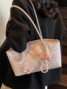 Pink lace tote bag with 3D butterfly embroidery and pearl charm on black suit background
