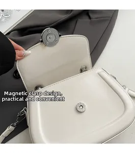 Dettaglio della fibbia magnetica e della ferramenta sulla borsa a sella crema