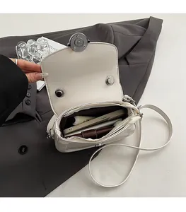 Vista dettagliata dell'interno della borsa a sella crema con chiusura magnetica e vano