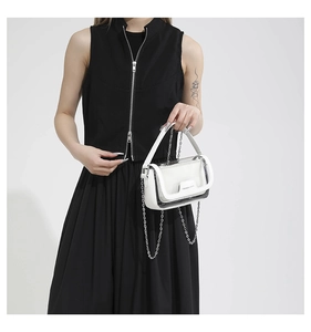 Détail d'un sac patchwork en cuir blanc et PVC transparent avec bandoulière chaîne