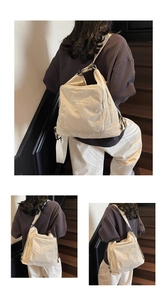 Detail view of cream canvas tote bag with pleated texture and adjustable strap design