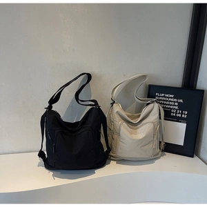 Detail view of large capacity nylon tote bags with multiple pockets in black and beige