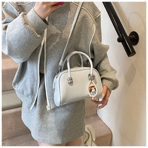 Macro shot of light blue glossy Boston bag with pearl charm and fashion logo detail