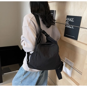 Detail of the black nylon travel tote showing large front pocket and comfortable strap