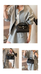 Three-way view of black textured crossbody bag with silver buckle and top handle