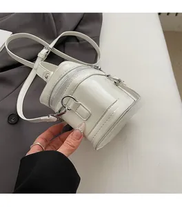 Detail view of the silver zipper and glossy white cylinder box bag with smooth PU finish