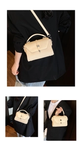 Detail view of cream structured crossbody bag with woven texture and silver round lock