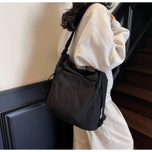 Detail of a large black nylon tote with adjustable strap and 'STREETS' print logo