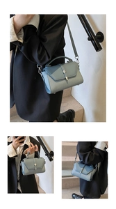 Detail of greyish-blue crossbody bag with woven texture panel and metal buckle