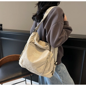 Detail view of cream oversized tote bag showing wrinkled fabric texture and BIFW print