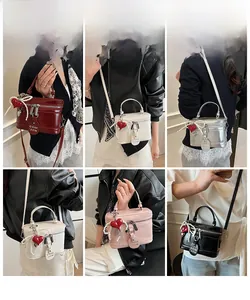 Detail view of mini box handbags in five colors with heart pendants and pearl chains