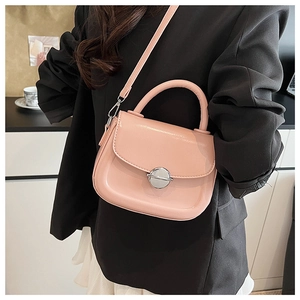Dettaglio borsa a sella in pelle rosa chiaro con chiusura argento e tracolla sottile