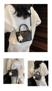 Détail du sac seau noir tressé avec peluche monstre décorative et bandoulière en métal