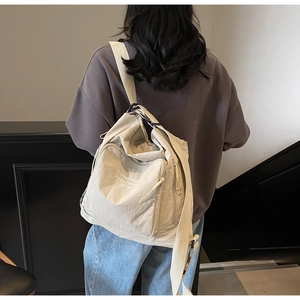 Rear view of a model wearing a beige nylon tote bag with versatile shoulder straps